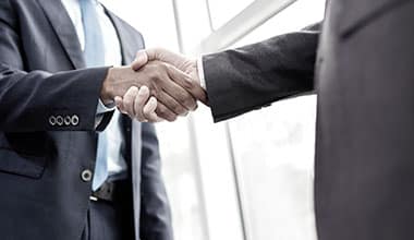two people in suits shaking hands on A-1 Anytime Bonding website for bail bonds in Panama City with experienced bondsmen